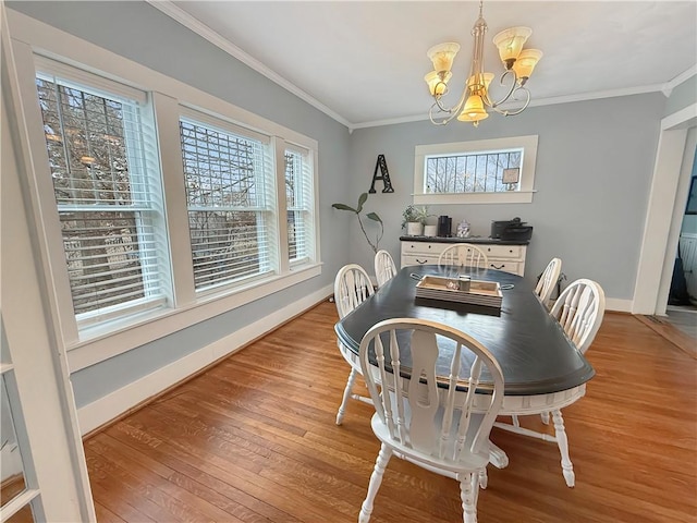 dining space featuring crown molding, a chandelier, and wood finished floors