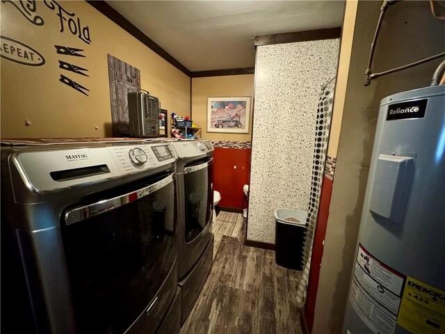 laundry room featuring electric water heater, ornamental molding, washer and dryer, and wood finished floors