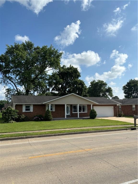 905 W Evergreen Ave, Effingham, IL 62401 - single story home with an attached garage, a front lawn, concrete driveway, and brick siding