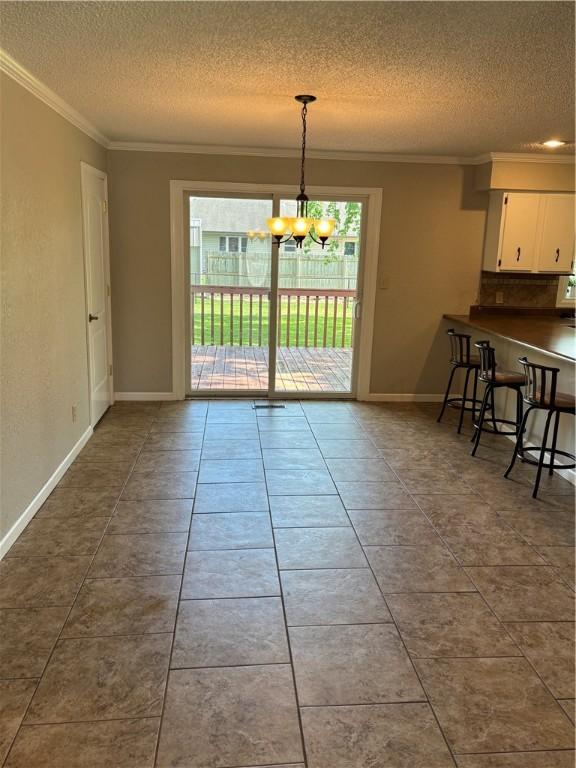 905 W Evergreen Ave, Effingham, IL 62401 - tiled dining space with ornamental molding, a textured ceiling, and a chandelier
