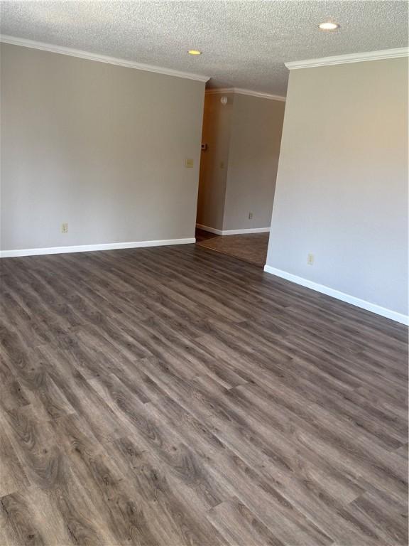905 W Evergreen Ave, Effingham, IL 62401 - empty room featuring a textured ceiling, dark wood-style flooring, ornamental molding, and recessed lighting
