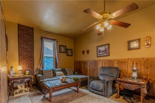 living room with wood walls, ceiling fan, and light colored carpet