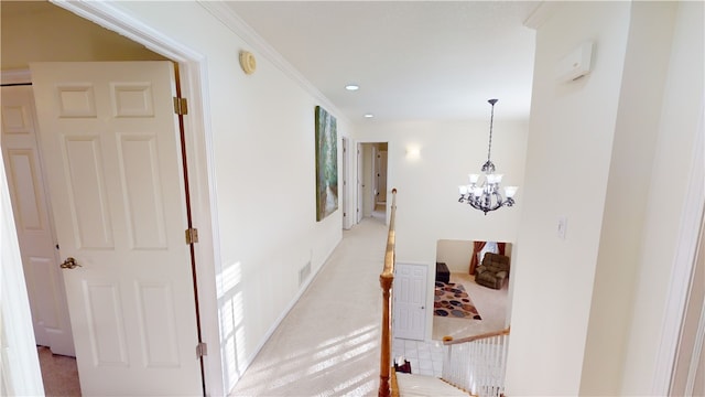 corridor with ornamental molding and a chandelier