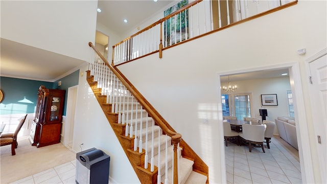 staircase featuring tile patterned flooring, crown molding, a wealth of natural light, and a towering ceiling