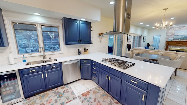 kitchen featuring blue cabinetry, stainless steel appliances, beverage cooler, and kitchen peninsula