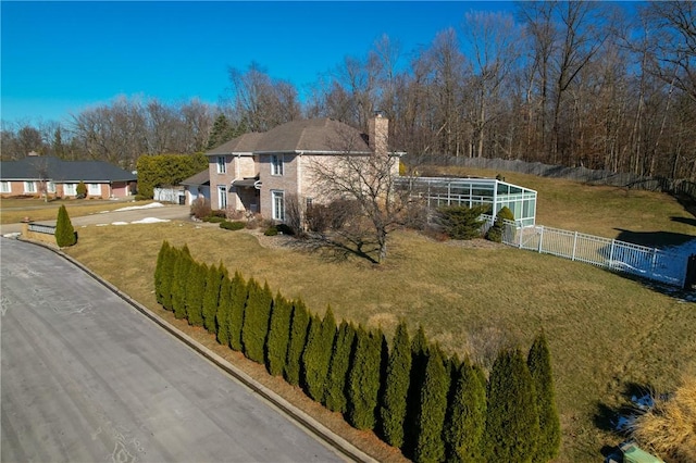 view of property exterior with a yard and glass enclosure