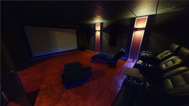 carpeted cinema featuring a drop ceiling