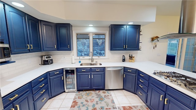 kitchen featuring blue cabinetry, sink, island range hood, stainless steel appliances, and beverage cooler