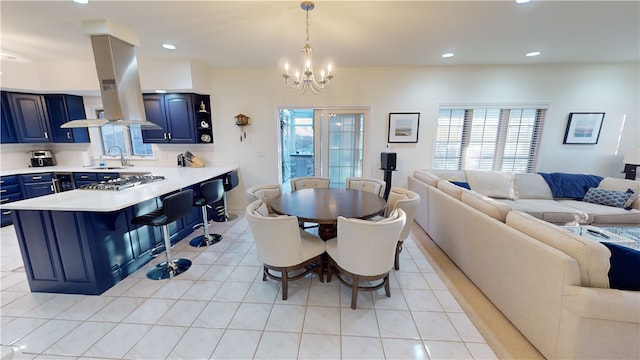 dining room featuring a notable chandelier, a healthy amount of sunlight, sink, and light tile patterned floors