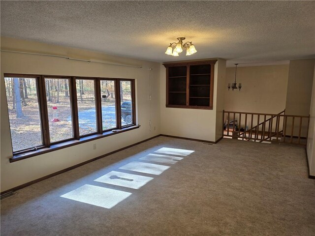 20746 E 400 N, Charleston, IL 61920 - empty room featuring a chandelier, carpet, a textured ceiling, and baseboards