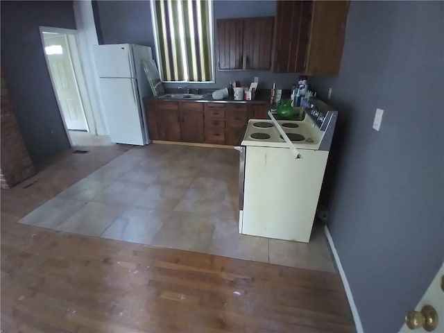 172 Broadway St, Shelbyville, IL 62565 - kitchen with brown cabinetry, white appliances, and a sink
