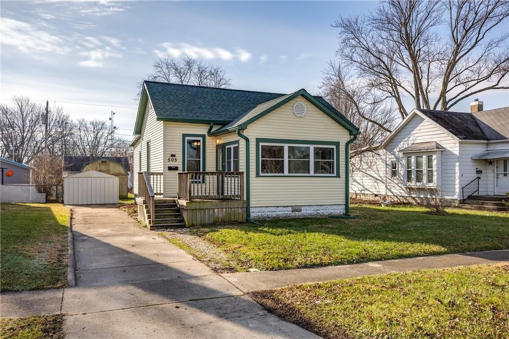 bungalow-style home featuring an outbuilding and a front lawn