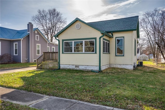 view of front of home with cooling unit and a front lawn