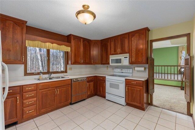 kitchen featuring visible vents, white appliances, light countertops, and a sink