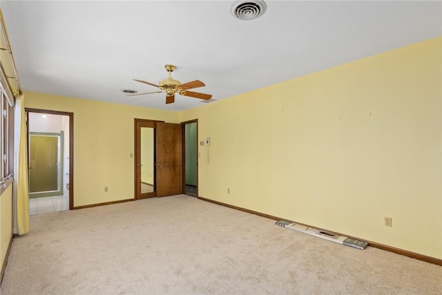 unfurnished bedroom with a ceiling fan, baseboards, visible vents, ensuite bath, and light carpet