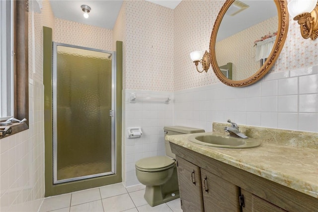 bathroom featuring wallpapered walls, tile walls, a wainscoted wall, and tile patterned flooring