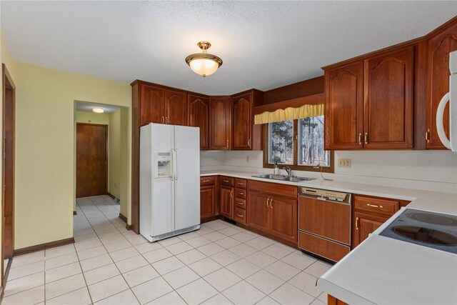 kitchen featuring light countertops, paneled dishwasher, white refrigerator with ice dispenser, and a sink