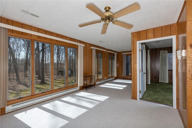 unfurnished sunroom with visible vents, baseboard heating, and ceiling fan