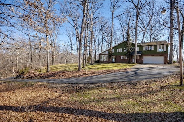 view of yard with aphalt driveway and a garage