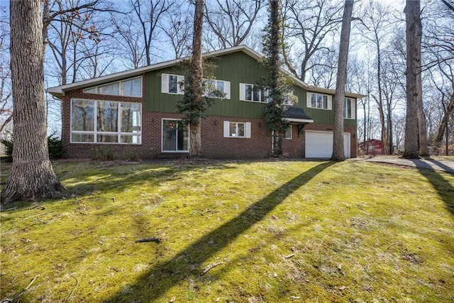 view of front of house featuring a front yard, a garage, brick siding, and a sunroom