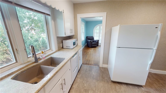 104 E N St, Ridgefarm, IL 61870 - kitchen with white appliances, white cabinetry, light stone counters, light wood-style flooring, and backsplash