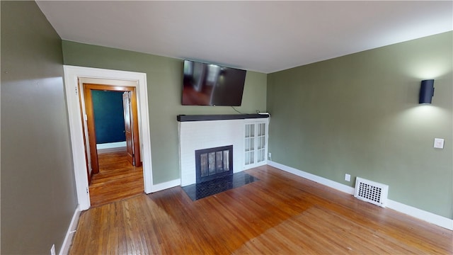 104 E N St, Ridgefarm, IL 61870 - unfurnished living room featuring a fireplace with flush hearth and wood finished floors