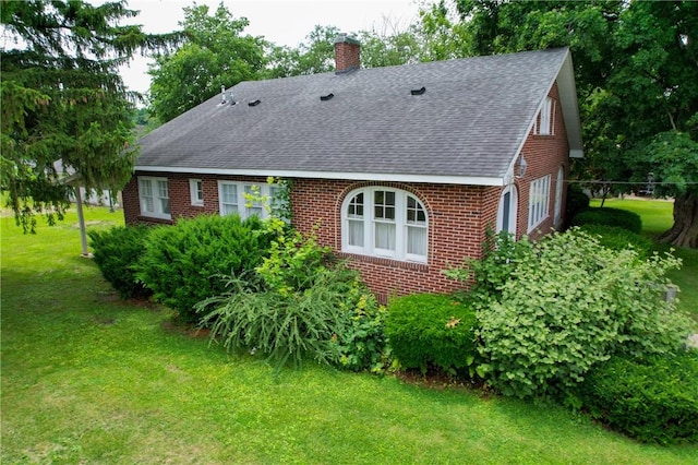 104 E N St, Ridgefarm, IL 61870 - rear view of house with roof with shingles, a chimney, a lawn, and brick siding