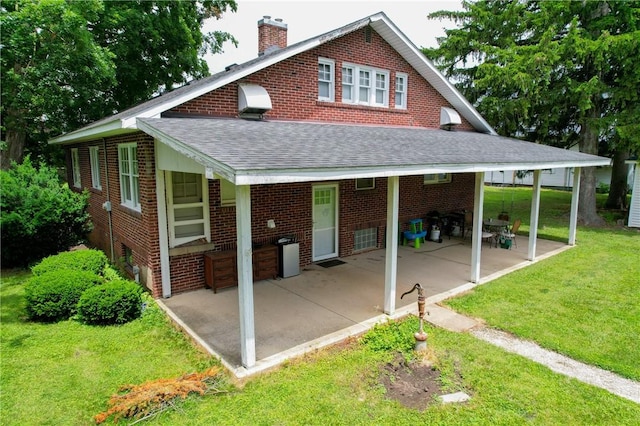 104 E N St, Ridgefarm, IL 61870 - back of property with brick siding, a chimney, a shingled roof, a lawn, and a patio
