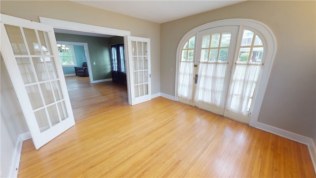 104 E N St, Ridgefarm, IL 61870 - empty room with french doors, light wood-type flooring, and a chandelier