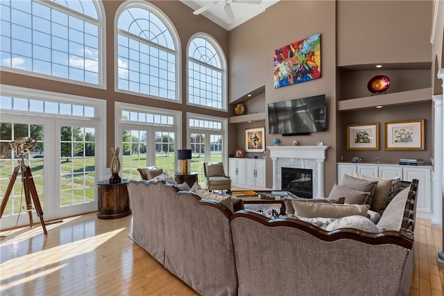 living room with a high ceiling, light hardwood / wood-style floors, and a wealth of natural light