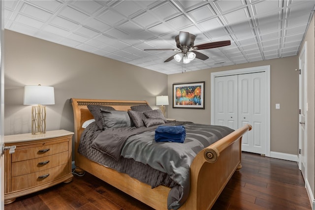 bedroom with ceiling fan, a closet, and dark hardwood / wood-style floors