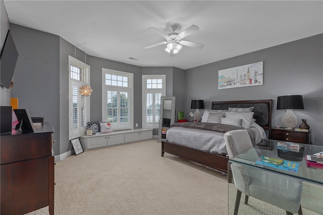 bedroom with light carpet, multiple windows, and ceiling fan