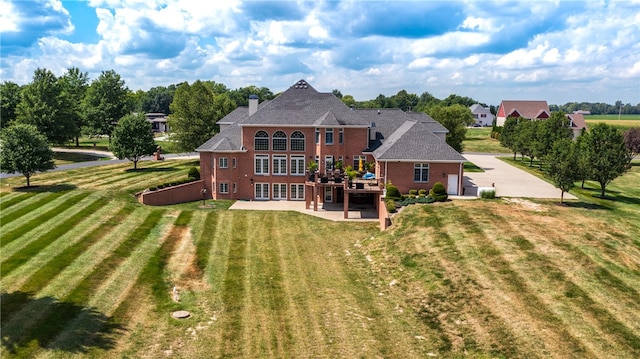 rear view of house with a patio and a lawn