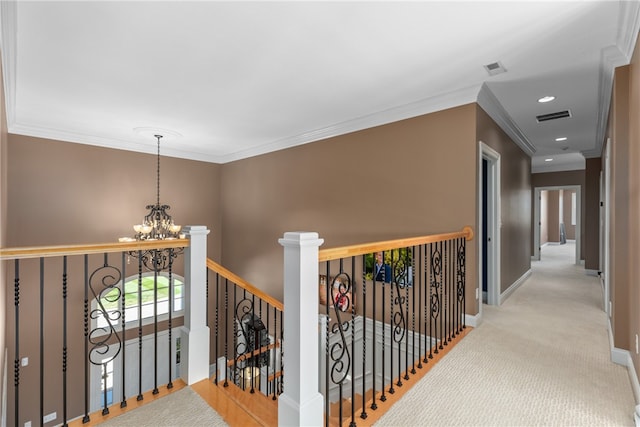 corridor with crown molding, light colored carpet, and a notable chandelier