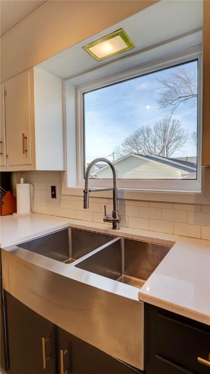 kitchen with backsplash, sink, and white cabinets