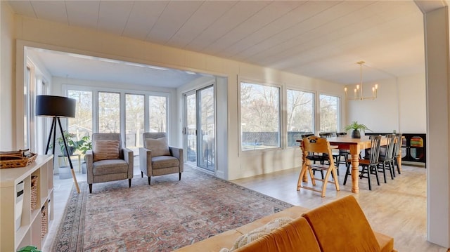 sunroom / solarium with plenty of natural light and a chandelier