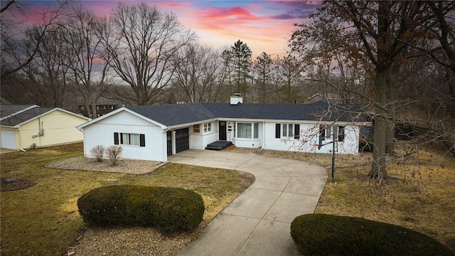 single story home with a garage and a lawn