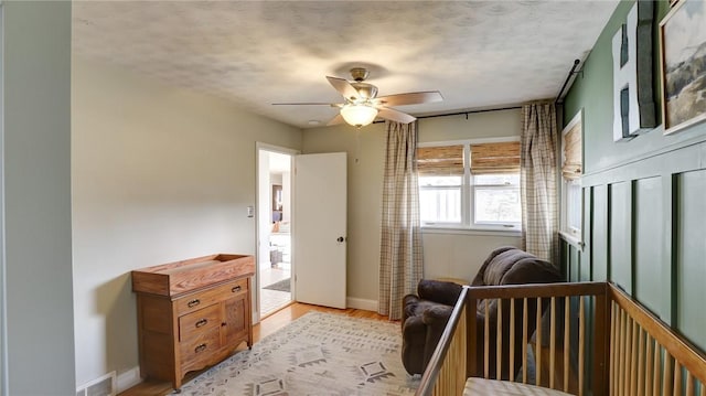 bedroom featuring a textured ceiling, ceiling fan, and light hardwood / wood-style flooring