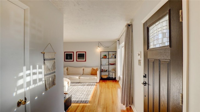 foyer with a textured ceiling and light hardwood / wood-style flooring