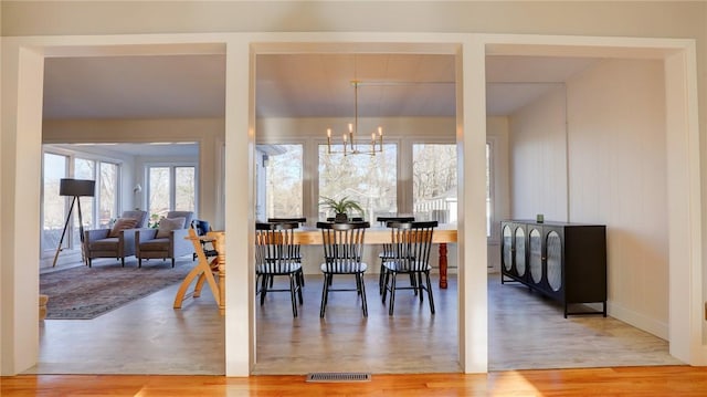 dining room with wood-type flooring and a notable chandelier