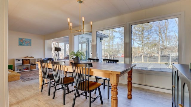 dining area featuring a notable chandelier and light wood-type flooring