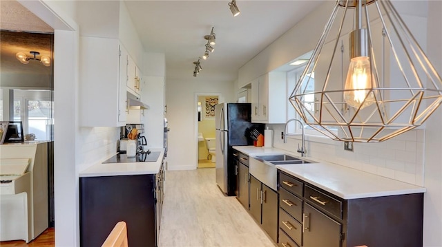 kitchen with dark brown cabinetry, sink, light hardwood / wood-style flooring, decorative backsplash, and white cabinets