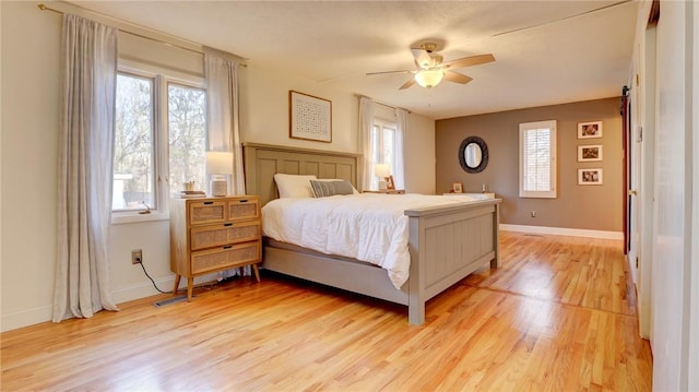 bedroom featuring multiple windows, ceiling fan, and light wood-type flooring