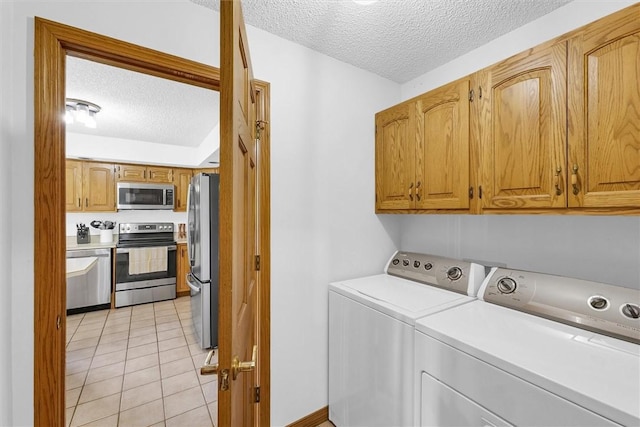 514 W Coolidge Ave, Charleston, IL 61920 - laundry room featuring independent washer and dryer, a textured ceiling, cabinet space, and light tile patterned floors