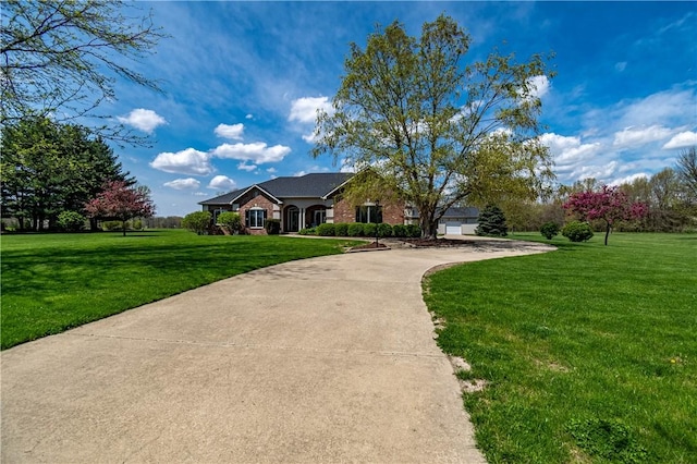 ranch-style home with brick siding, a garage, a front yard, and concrete driveway