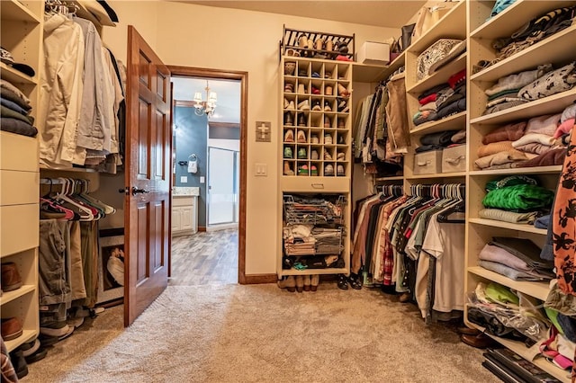 spacious closet featuring a chandelier and carpet