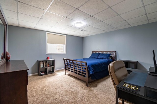 bedroom with a drop ceiling, baseboards, and carpet floors
