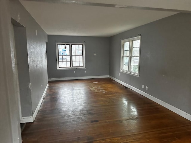 unfurnished room with dark hardwood / wood-style flooring