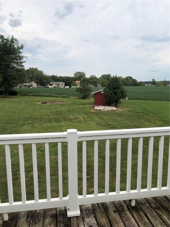 view of yard with an outdoor structure, a deck, and a shed