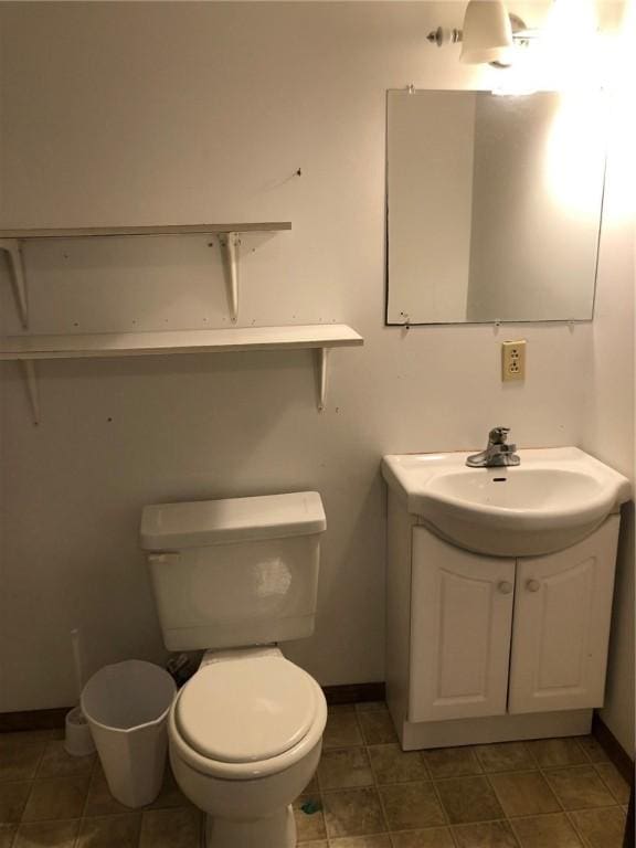 bathroom with toilet, baseboards, and vanity